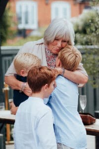 Woman being hugged by grandchilden at relaxed winchester wedding