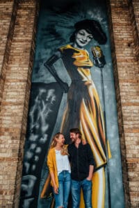 Couple sat in front of a mural at Alexander Palace, alternative wedding photography.